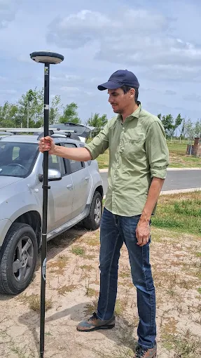 Agrimensor utilizando un receptor satelital GNSS junto a una parcela